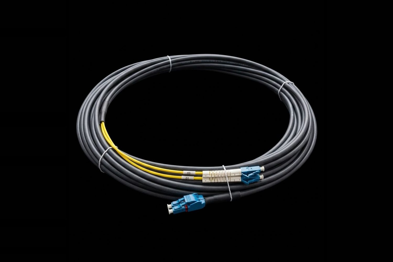 Coiled grey armoured fibre cable breaking out into yellow legs with blue LC connectors