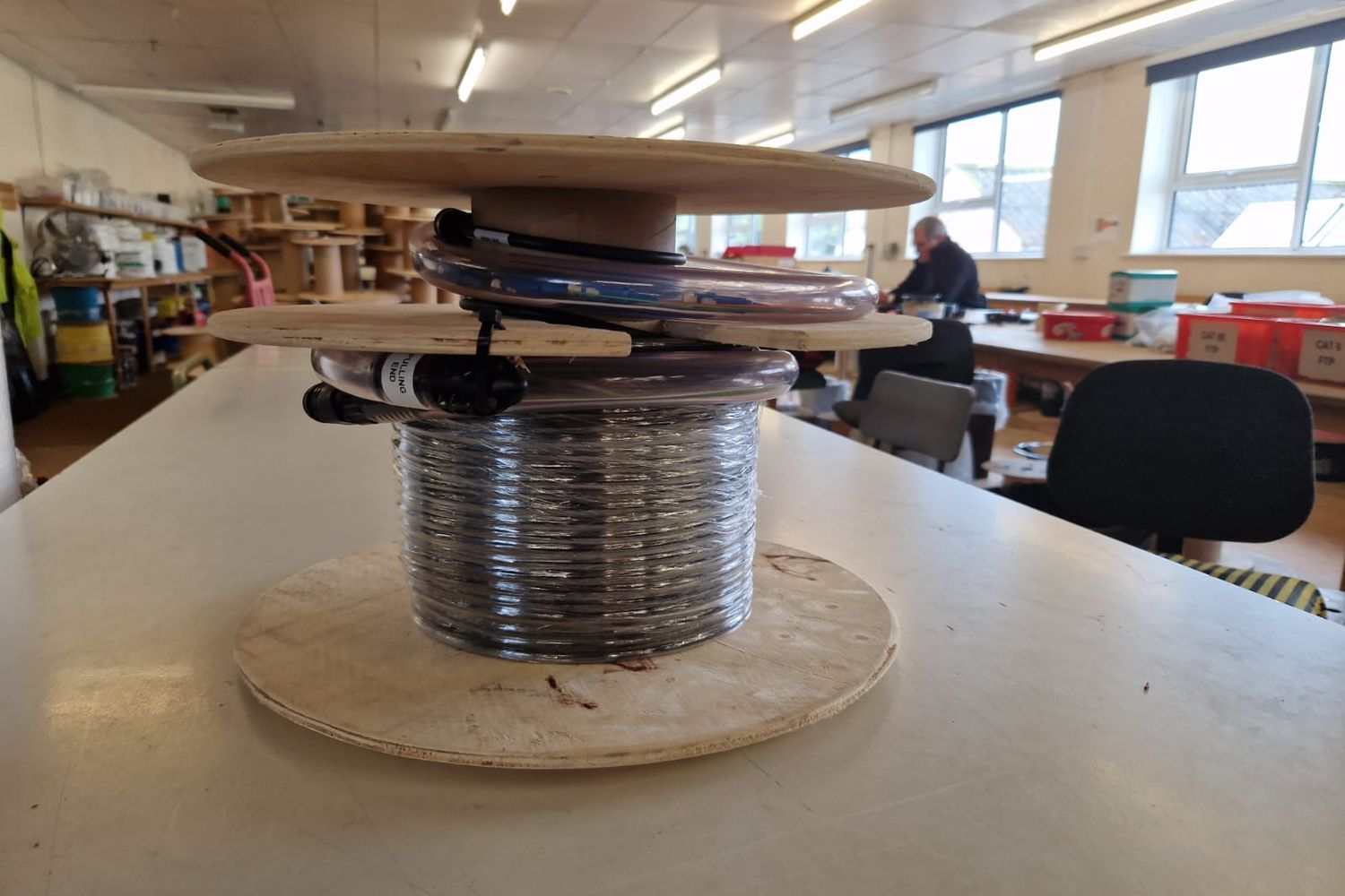 Pre-terminated multicore fibre assembly wound on a wooden drum, with the terminated ends protected in pulling tubes